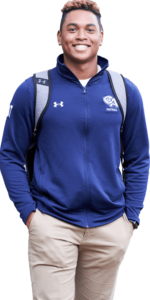 Male student smiles at the camera while wearing Cheshire Academy merchandise.