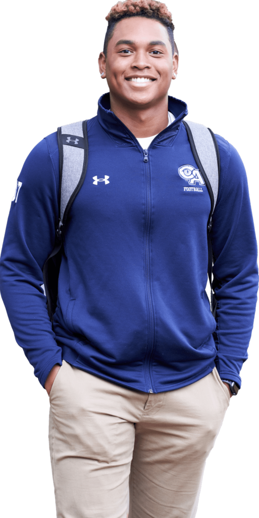 Male student smiles at the camera while wearing Cheshire Academy merchandise.