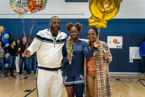 Girls basketball player poses for a photo with her family