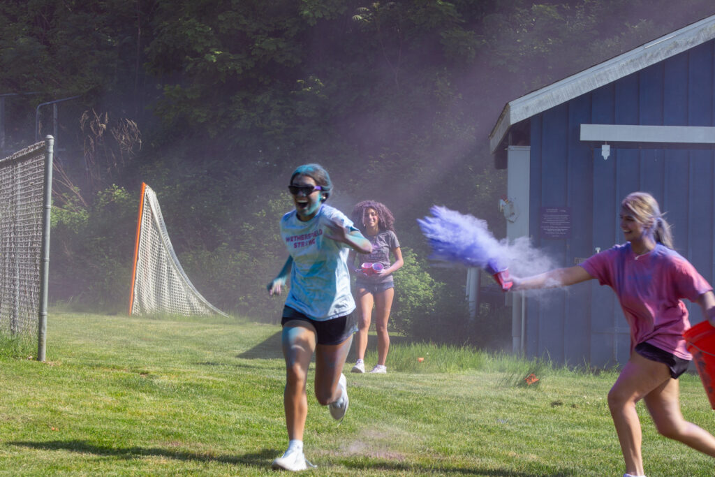 Student running in colored dust at Cheshire Academy